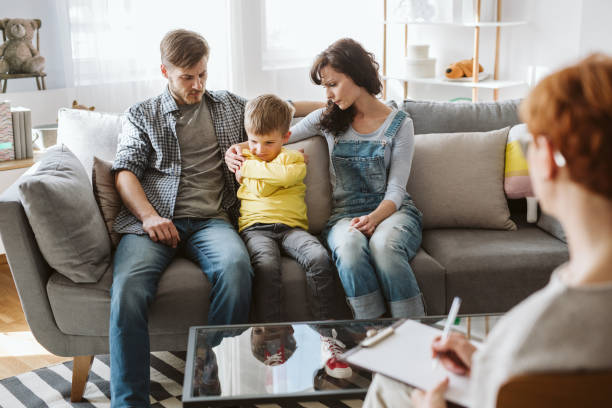 Caring parents and misbehaving boy during therapy session with counselor