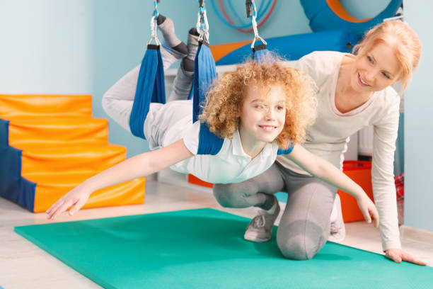 Boy and his therapist exercising during sensory integration therapy